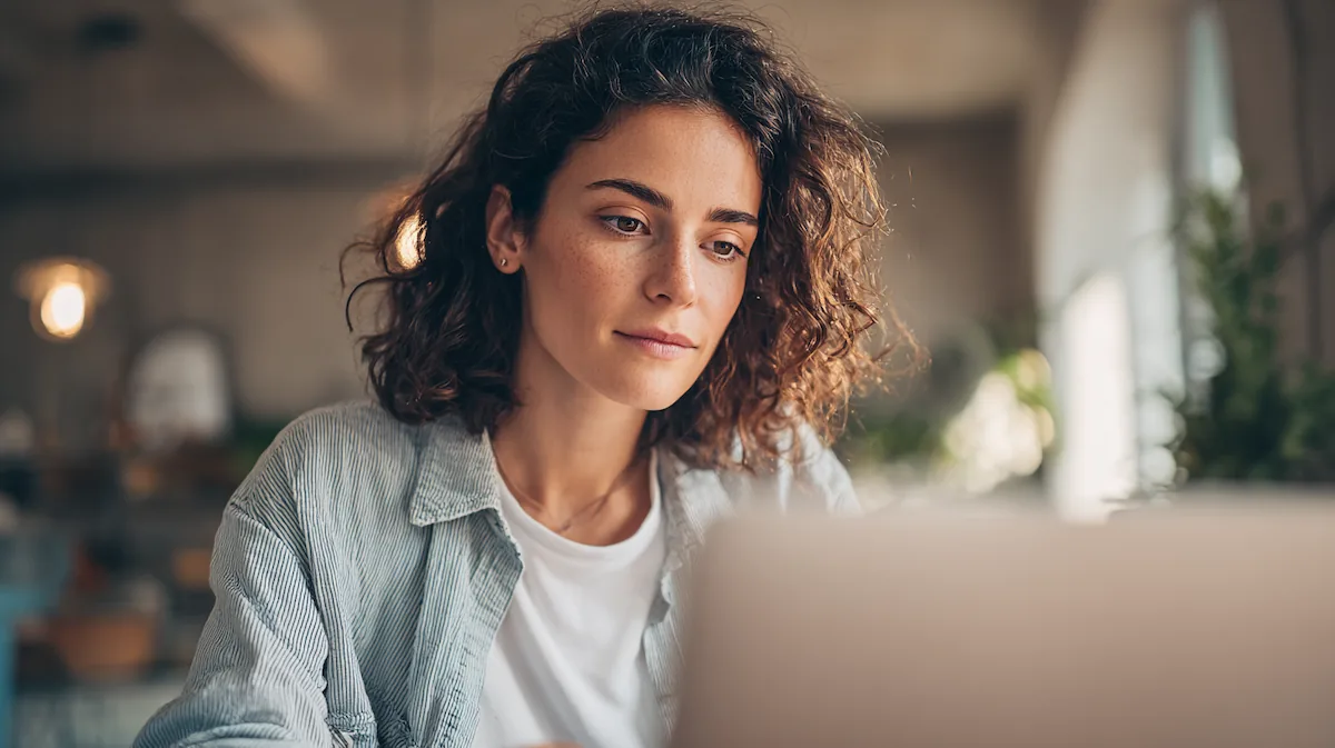A woman works casually on a laptop to illustrate the flexibility of an intensive outpatient program.