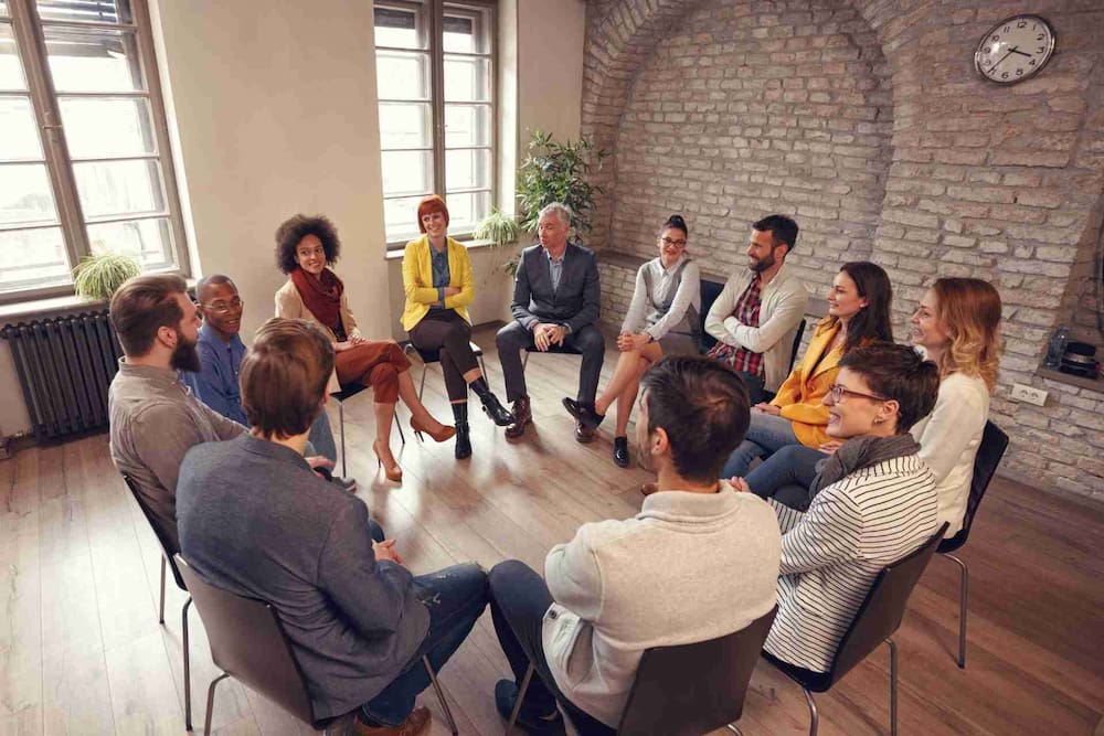 Therapist leading a supportive group therapy session for mental health treatment