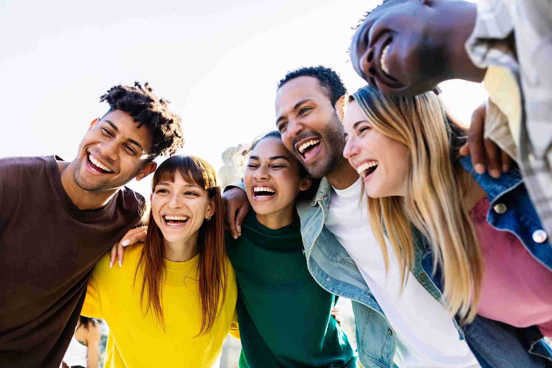 Diverse group of friends smiling together outdoors during a supportive community gathering
